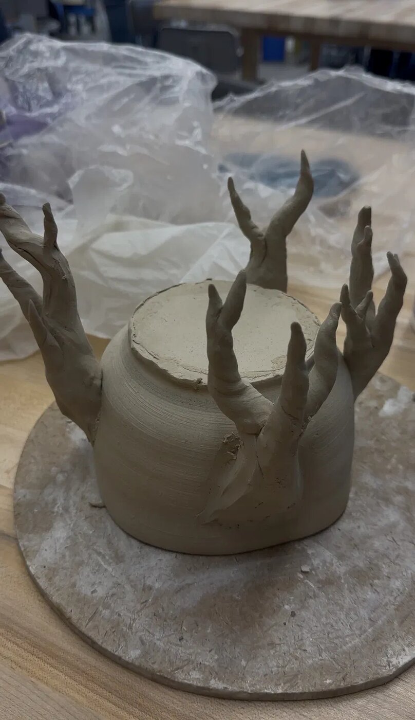 Vessel with branch-like forms reaching up from the rim, shown unfired