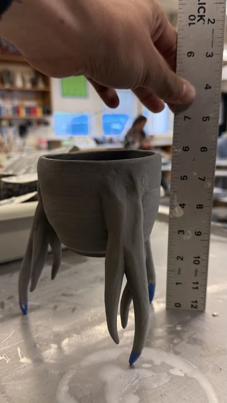 Wheel-thrown cup with hand-built root-like tentacles reaching down from the base